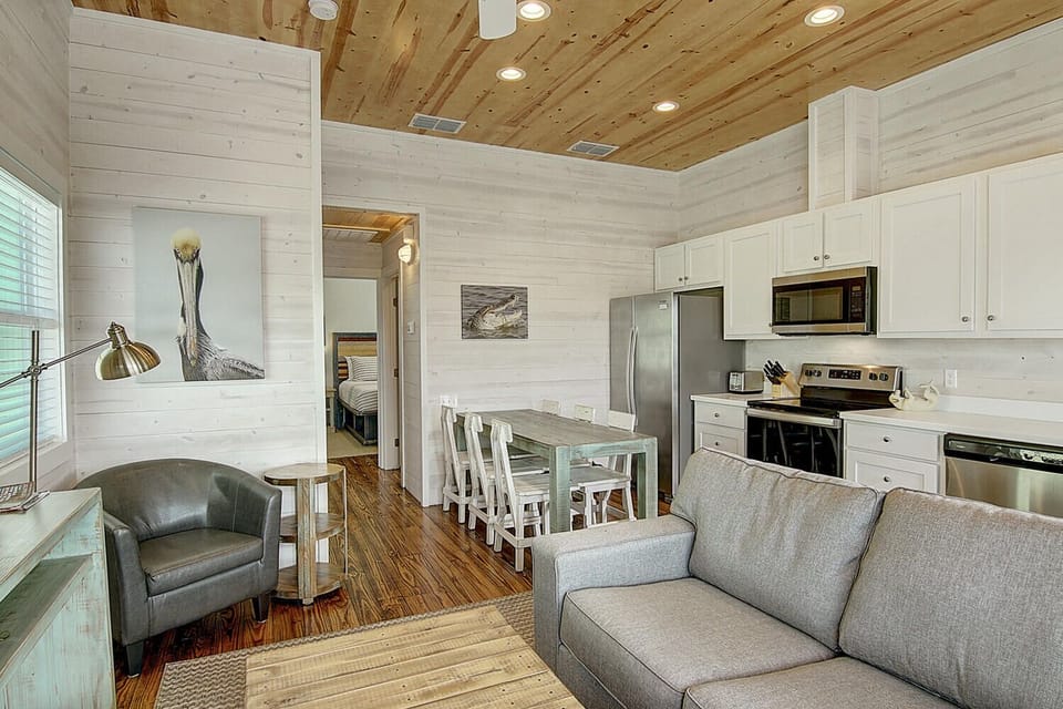 Relax in this beautifully designed open-concept space where coastal charm meets modern comfort with stunning wood ceiling details and thoughtfully curated furnishings.