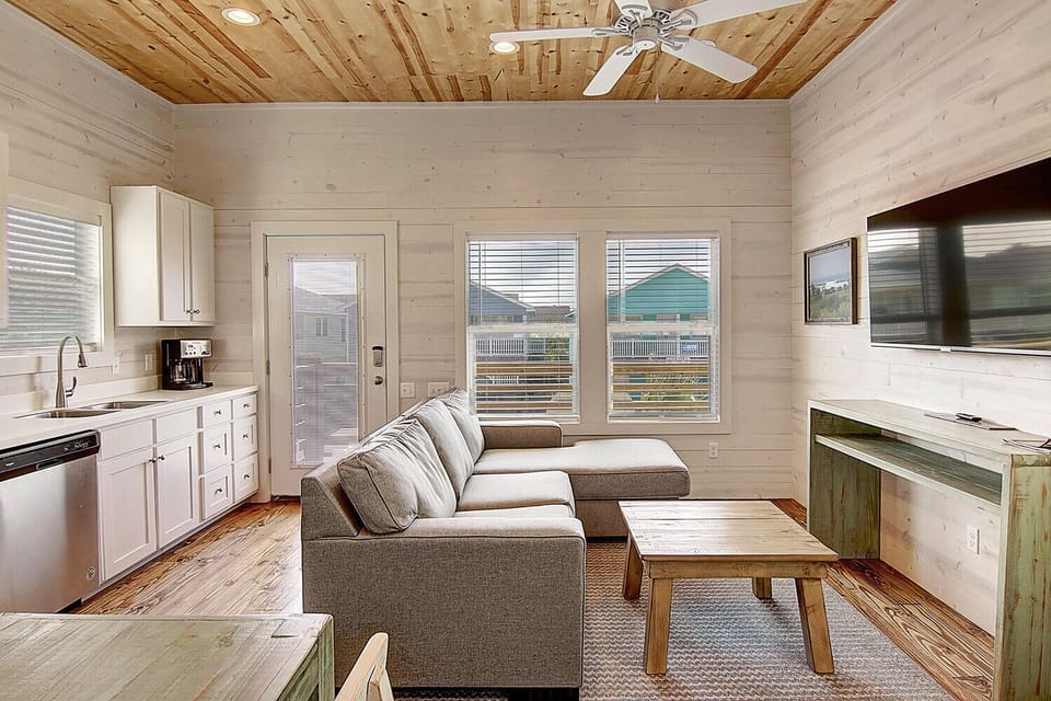 Unwind in your bright, open living space where kitchen, dining, and lounge flow together seamlessly under stunning wooden ceilings.