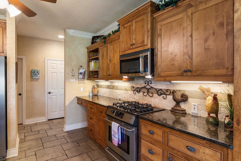 The pretty wood cabinetry in the kitchen opens up to plenty of cooking ware, dining ware, utensils, and glasses.