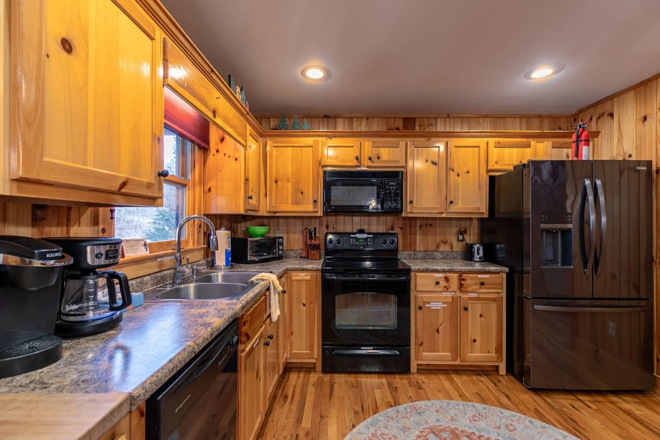 A fully equipped kitchen ready for big group meals, with warm knotty pine cabinets and plenty of counter space.