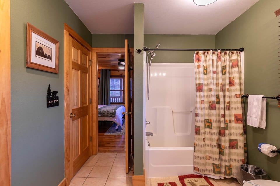 A cozy cabin bath with rustic wildlife accents, steps from the bedroom at Riverbend Retreat.