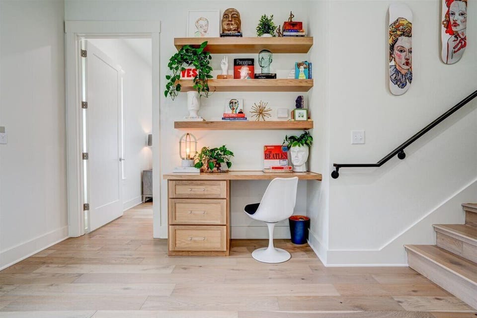 Sunny landing with wall of windows, desk, and fully stocked laundry area.