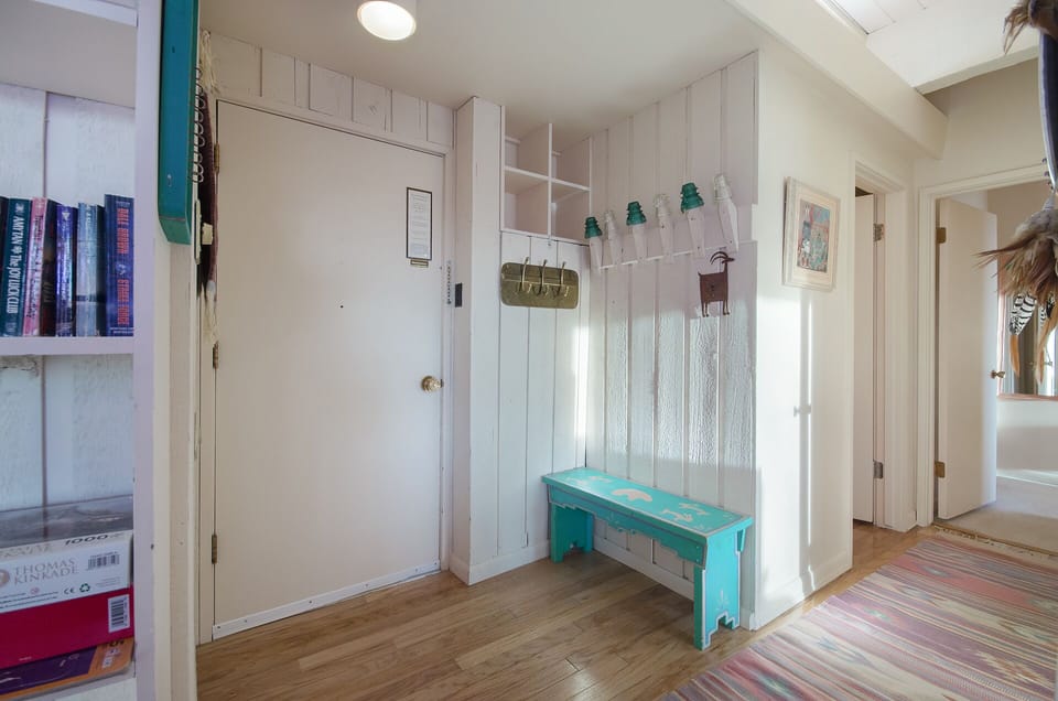 Step into this charming coastal entryway where turquoise accents and white-washed wood create your perfect beach house welcome.