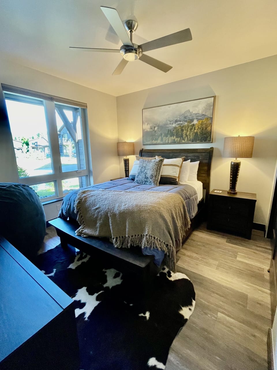 Downstairs Queen bedroom w/ queen sized bed, 2 side tables, and flat screen TV.