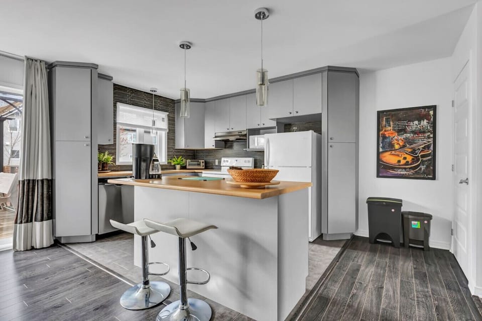 Modern kitchen with island, appliances, and natural light.