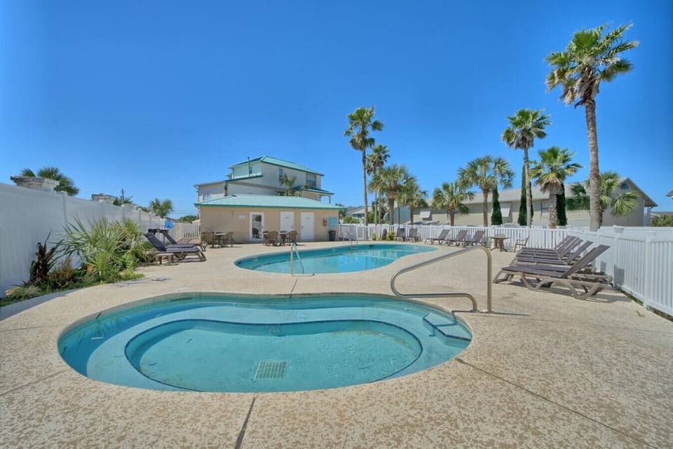Lounge under swaying palms by the sparkling pool and soothing hot tub.