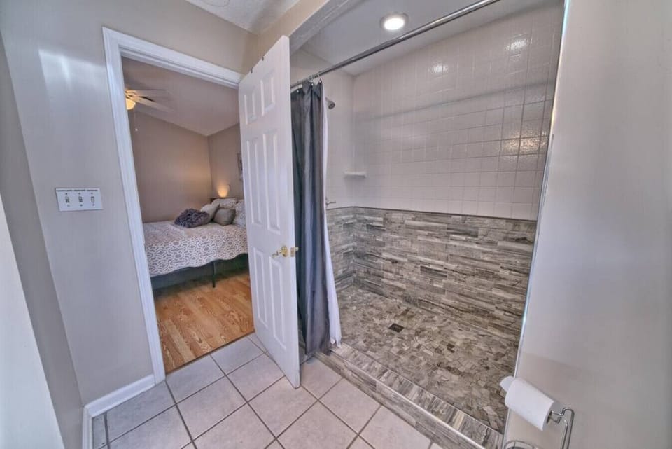 Private en-suite with a sleek walk-in shower and modern tile detail.