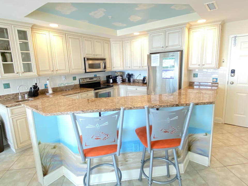 Modern kitchen with granite countertops, stainless steel appliances and island with extra  seating.