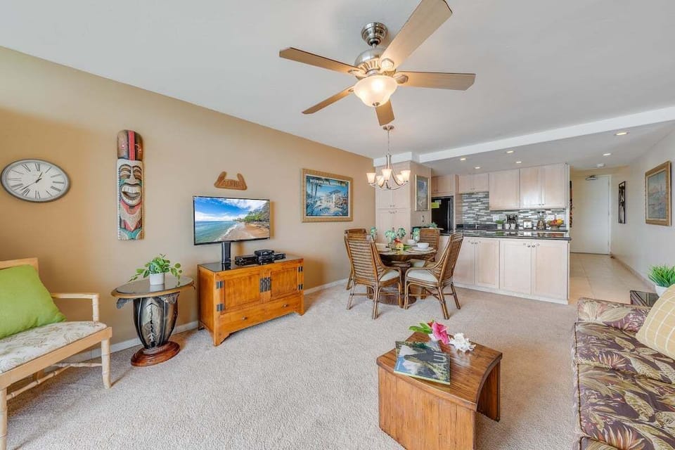 Open layout featuring cozy seating, a flat-screen TV, and direct balcony access