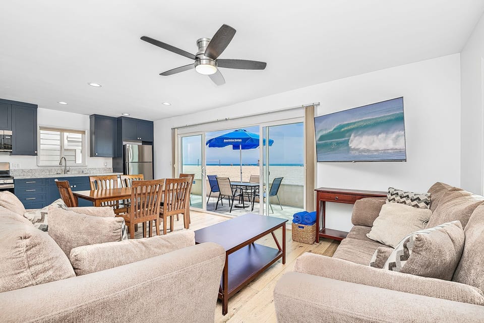 Open-concept living and dining area with direct oceanfront patio access
                