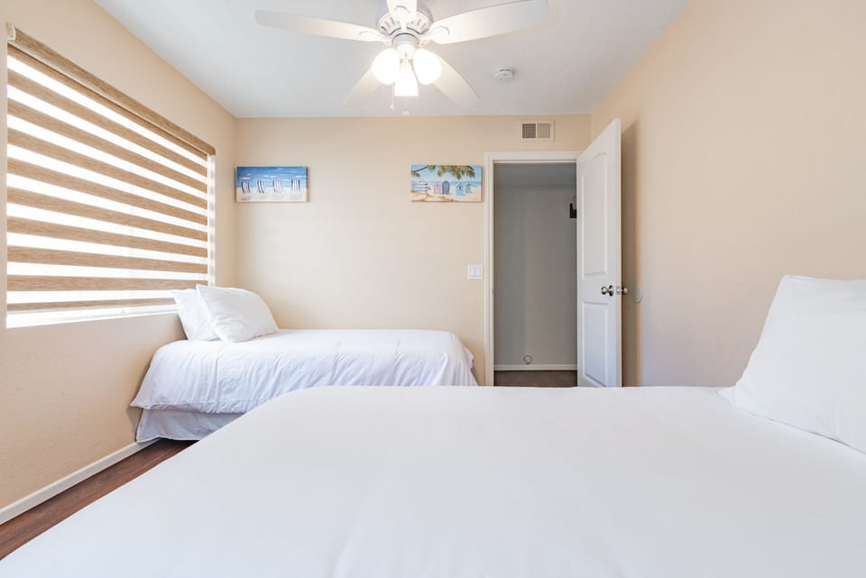 Third bedroom includes two twin beds and ceiling fan.
                