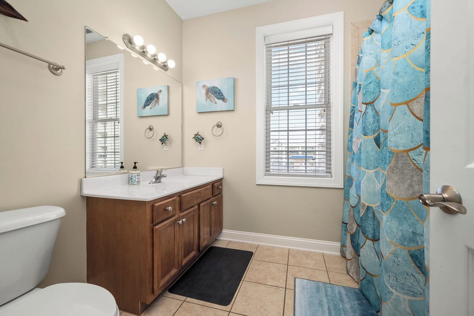 Bright coastal-style en-suite bathroom with natural light and spacious vanity