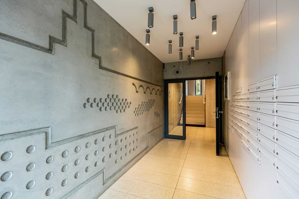 A sleek lobby with modern mailbox units, bright lighting, and wooden flooring, creating a welcoming atmosphere.