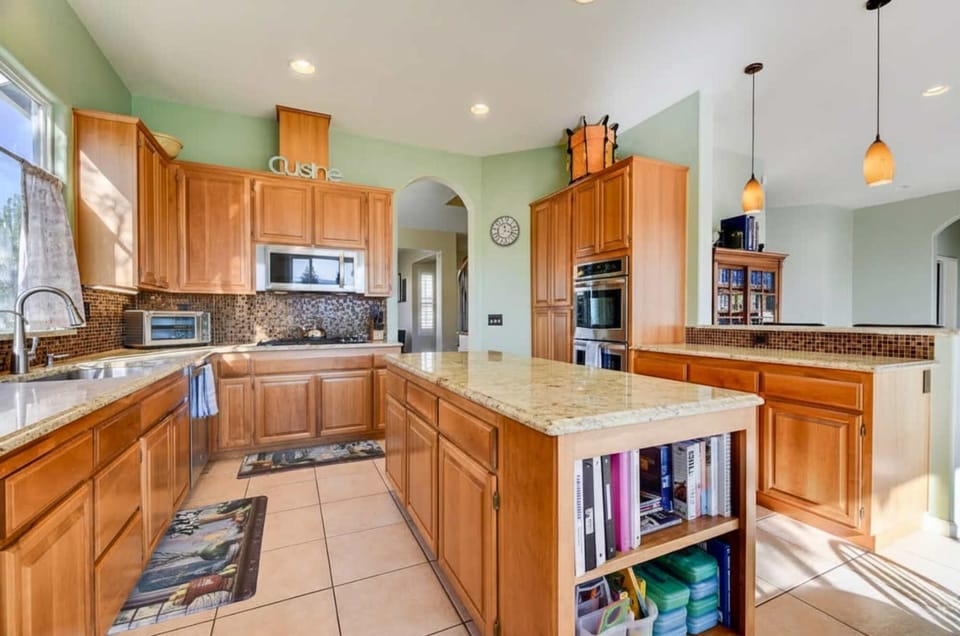Large, well-equipped kitchen with granite island and double ovens.