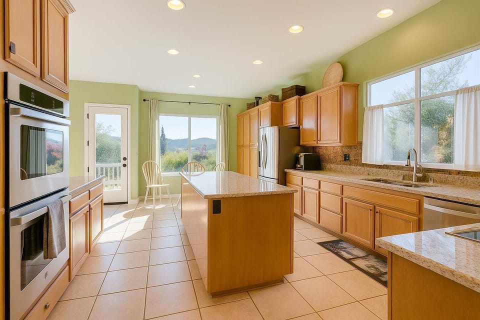 Sun-filled kitchen with a large island, stainless steel appliances, and beautiful mountain views right outside the windows.