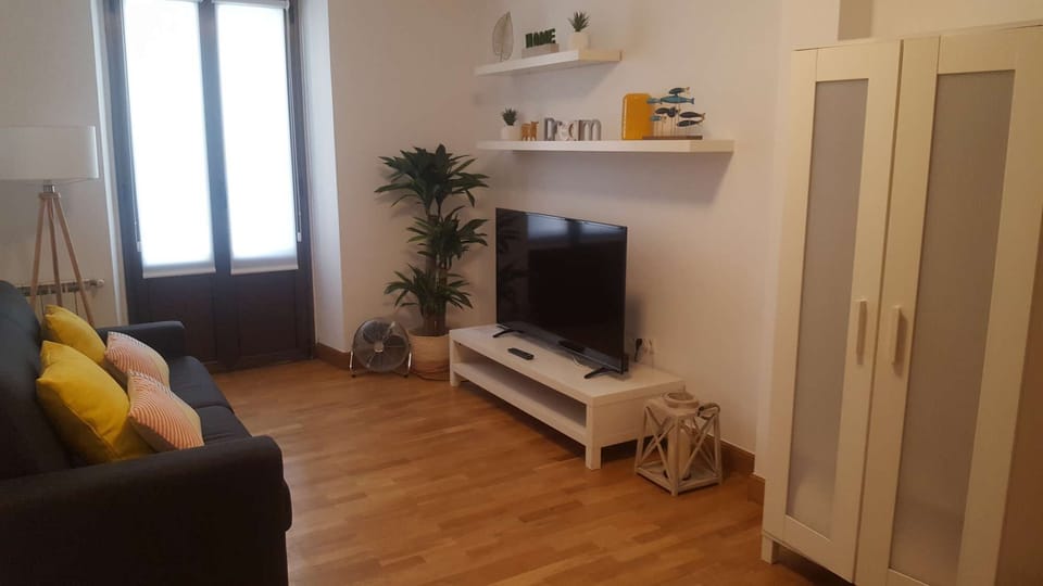 Spacious lounge with sofa, TV and balcony
