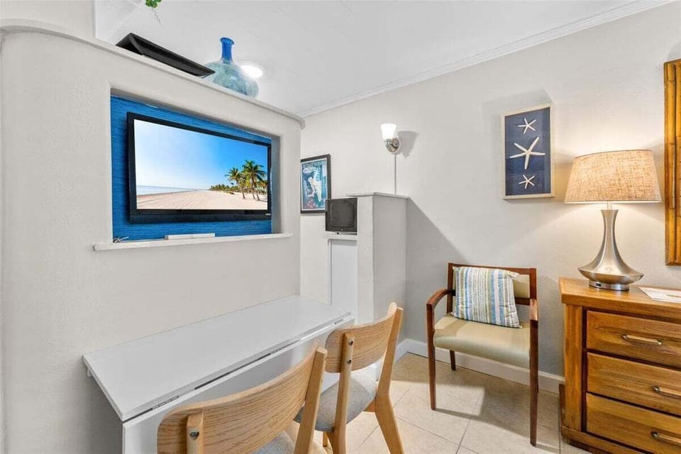 Cozy sitting area with a coastal blue-framed smart TV, beach-inspired décor, and a desk nook — perfect for unwinding after a day at the shore.