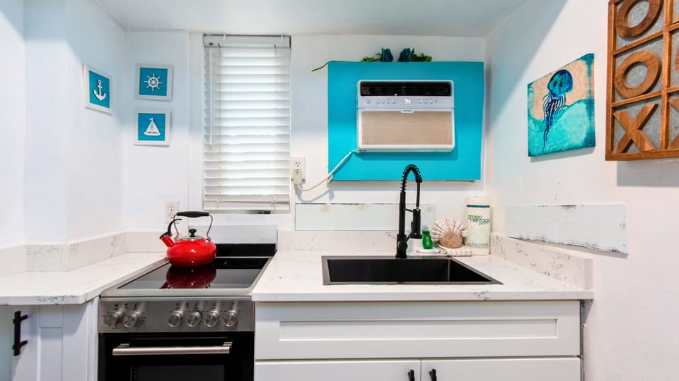 Includes a refrigerator, stove/oven, microwave, and a large coffee maker