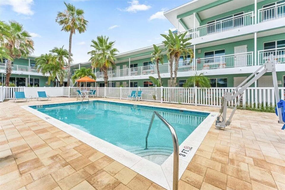 Dive into our sparkling saltwater pool with a spacious sun deck, lounge chairs, and handicap access — all surrounded by swaying palms, steps from the beach.
