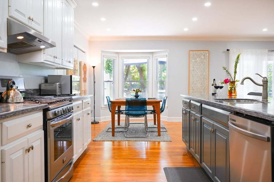 Kitchen with stainless range and sunny breakfast nook beyond