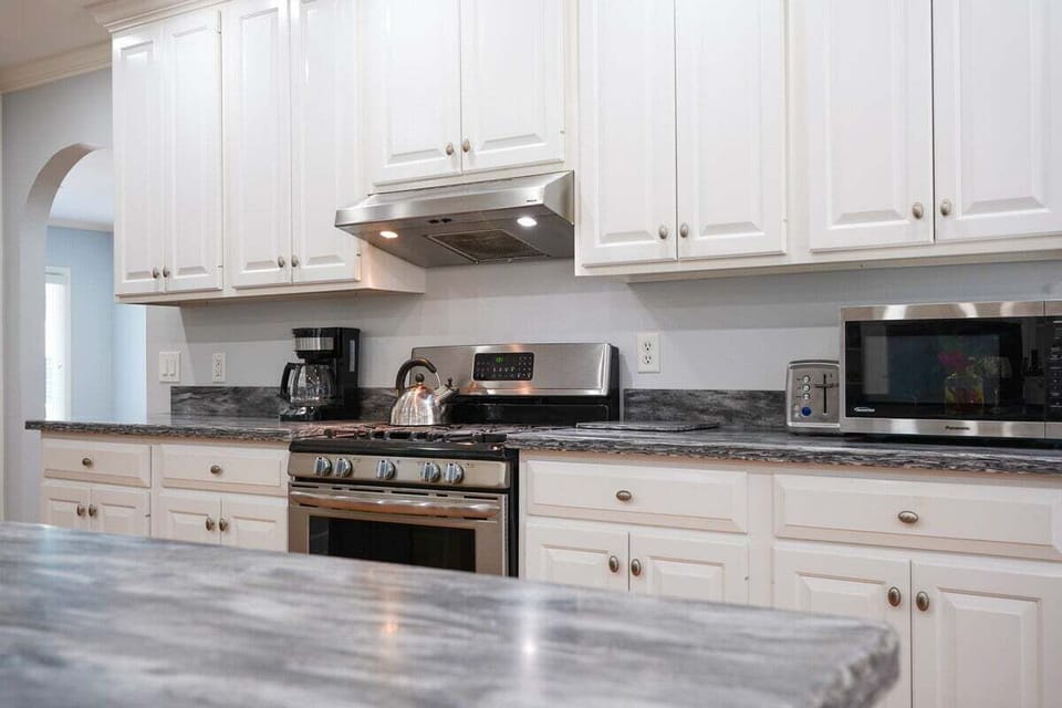 Kitchen closeup with white cabinets and dark granite counters