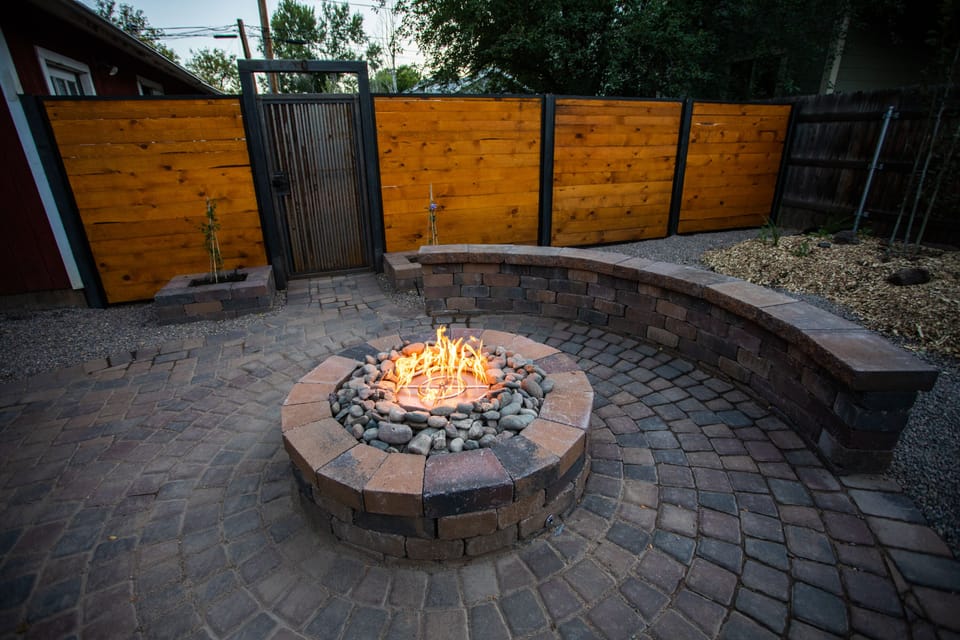 Fire pit and patio surrounded by well manicured yard