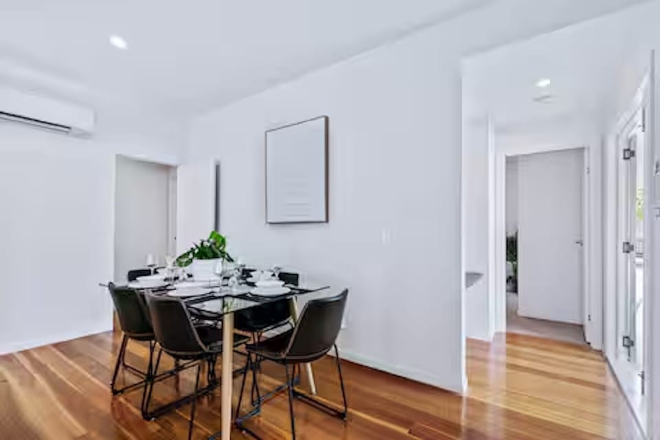 Timber floors and pendant lighting warm the dining area.