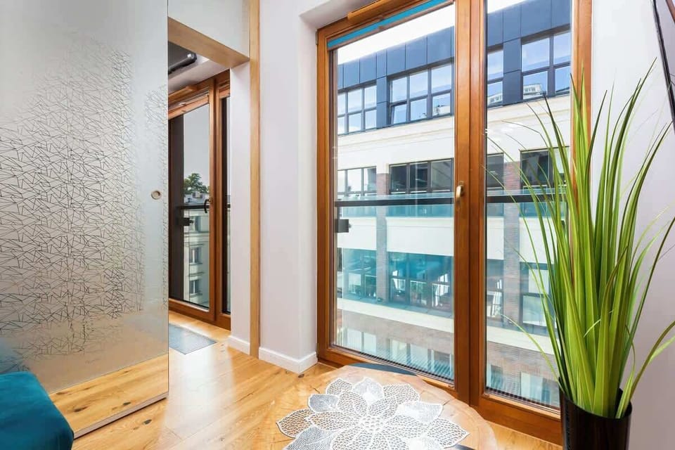  A glimpse into the balcony from the living room, showcasing natural light and greenery through the glass doors.