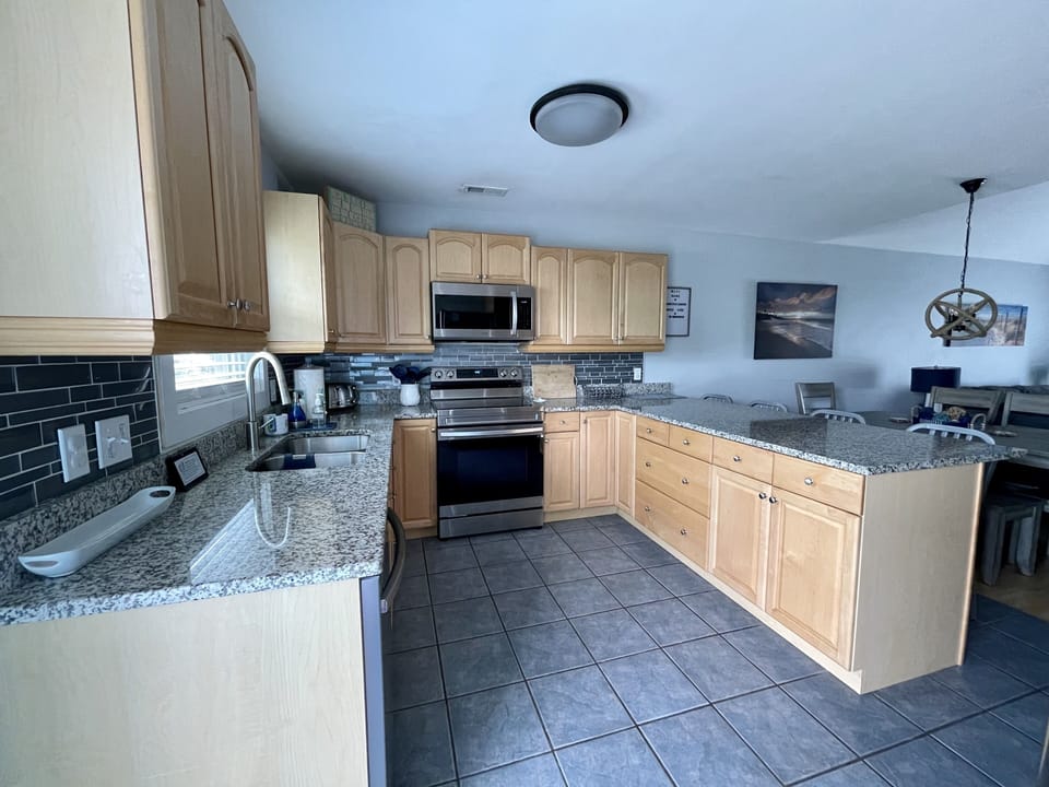 Bright, open, fully stocked kitchen with new stainless steel appliances