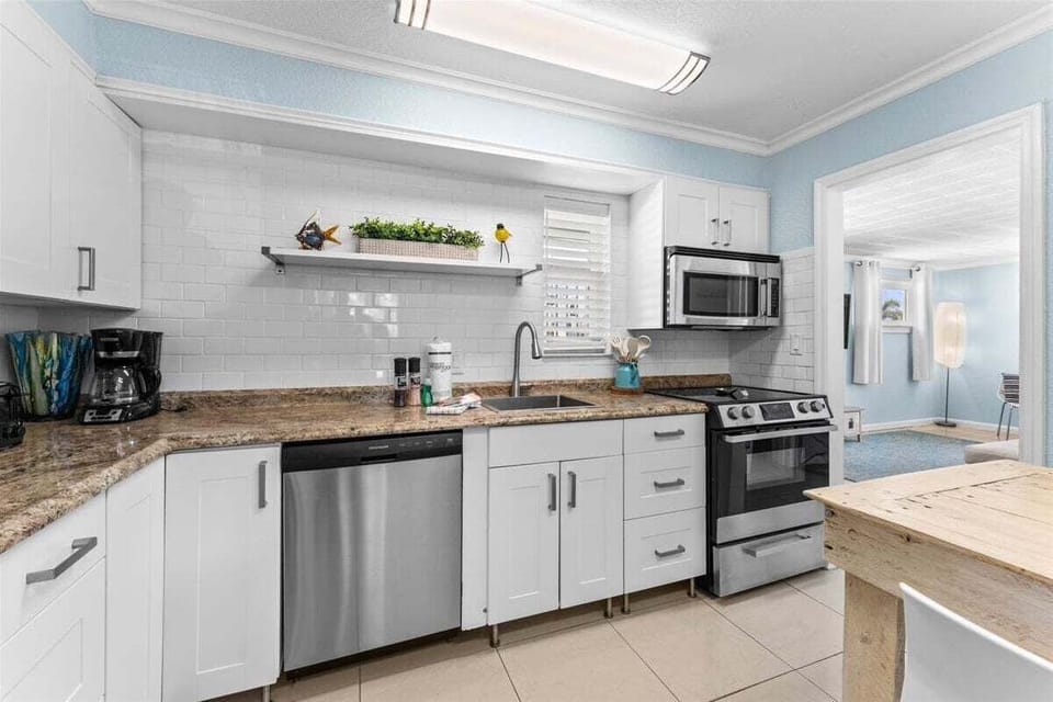 Fully equipped kitchen with granite counters, stainless steel appliances, dishwasher, and a cozy dining nook — everything you need for a home-cooked meal.