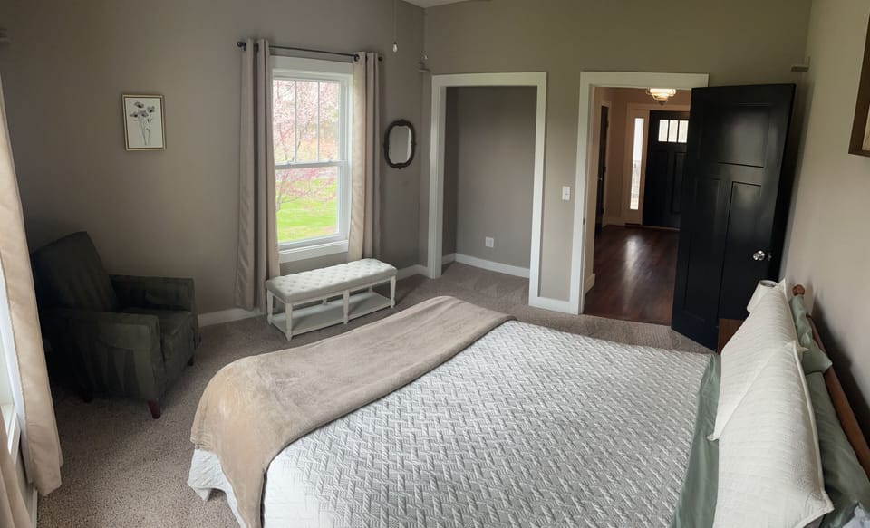 Main level guest bedroom with queen bed. 
View from back of bedroom. 