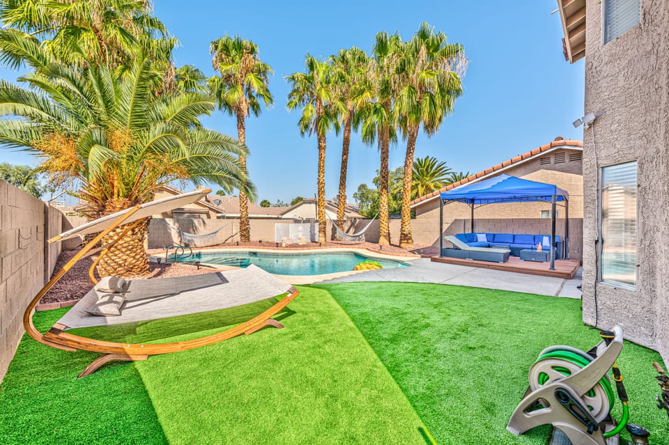 New artificial grass, tall palm trees, luxurious sun lounges, and a pool.