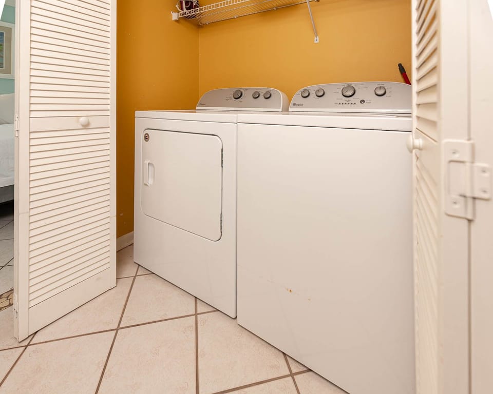 Conveniently do laundry with the washer and dryer in this cozy utility area, featuring bright yellow walls