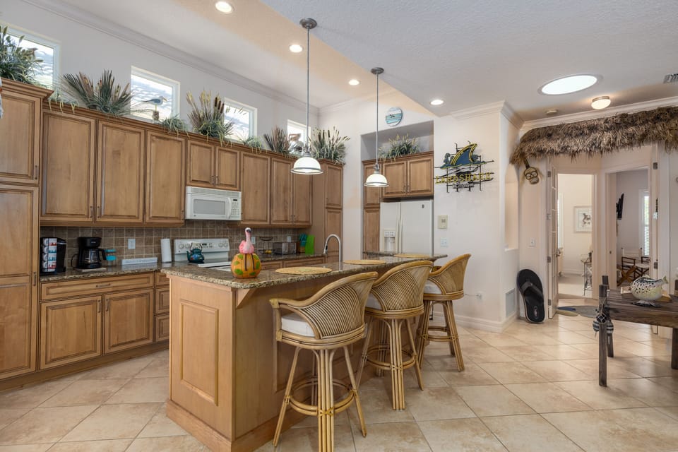 View of kitchen and bar from living area.
