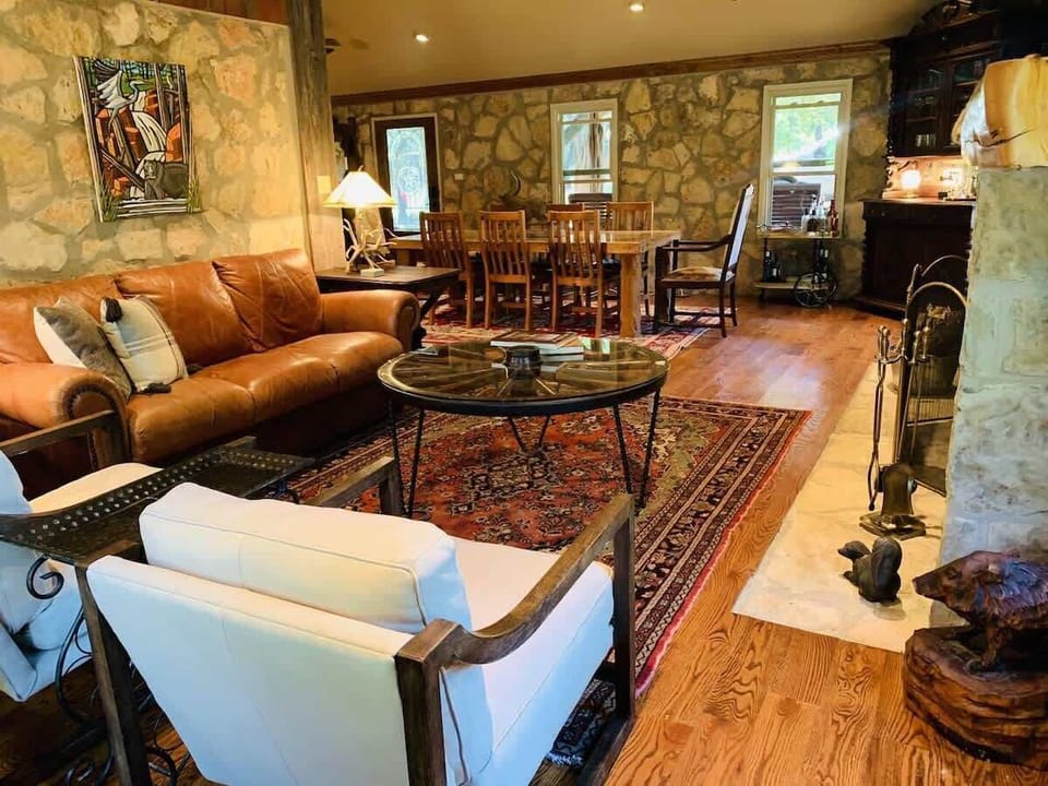 The Ranger main living and dining spaces with original rock walls and stone fireplace. This was the main lodge for the Girl Scout Camp with many songs sung and skits performed in this gathering space.