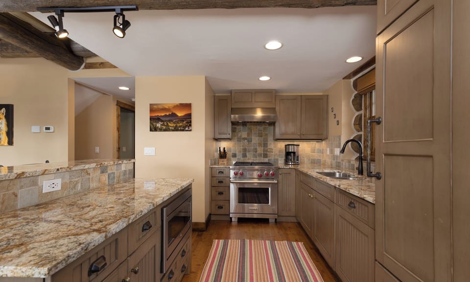 Step into your gourmet kitchen with granite counters and rustic wood beams—perfect for creating memorable meals during your stay.
