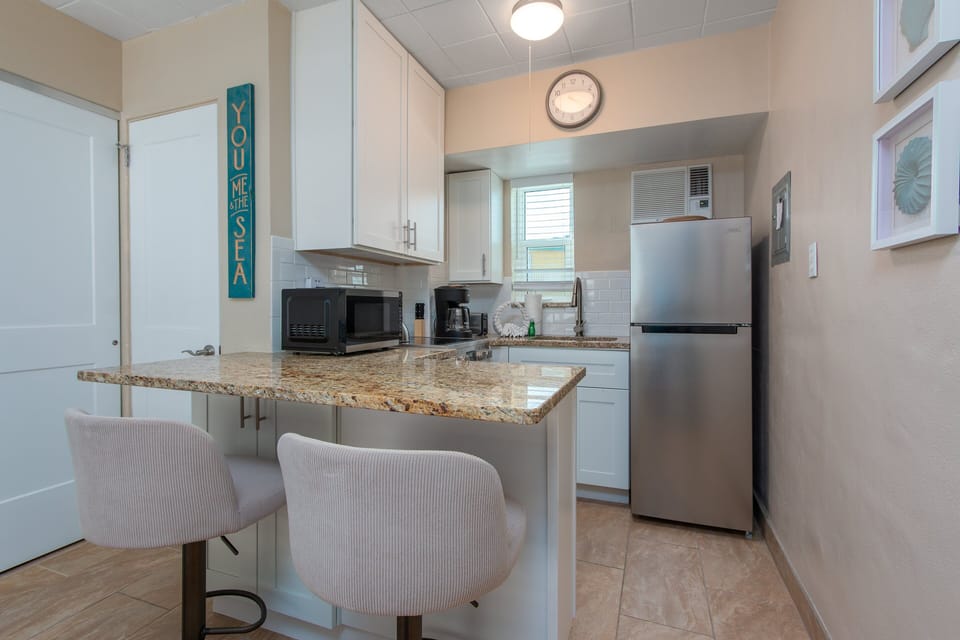 The kitchen is equipped with basics for convenience. It also has a mini breakfast bar to enjoy your meals, or it could double as a work station too!