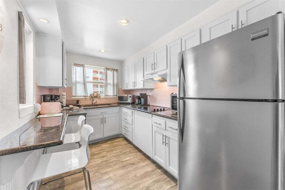 Fully equipped kitchen with stainless steel appliances, dark granite counters, and everything you need — dishwasher, stove, microwave, toaster oven, toaster, coffee maker, blender, and crock pot.