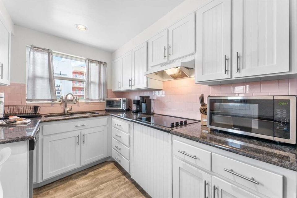 Fully equipped kitchen with stainless steel appliances, dark granite counters, and everything you need — dishwasher, stove, microwave, toaster oven, toaster, coffee maker, blender, and crock pot.