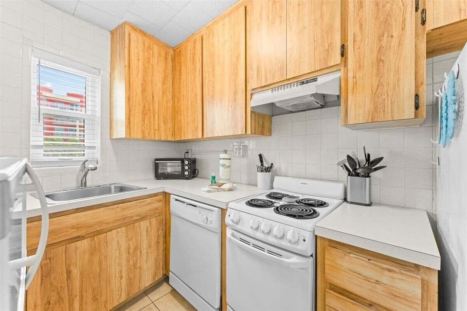 Fully equipped kitchen with wood cabinetry, stove, dishwasher, microwave, fridge, and coffee maker — everything you need for a home-cooked meal.