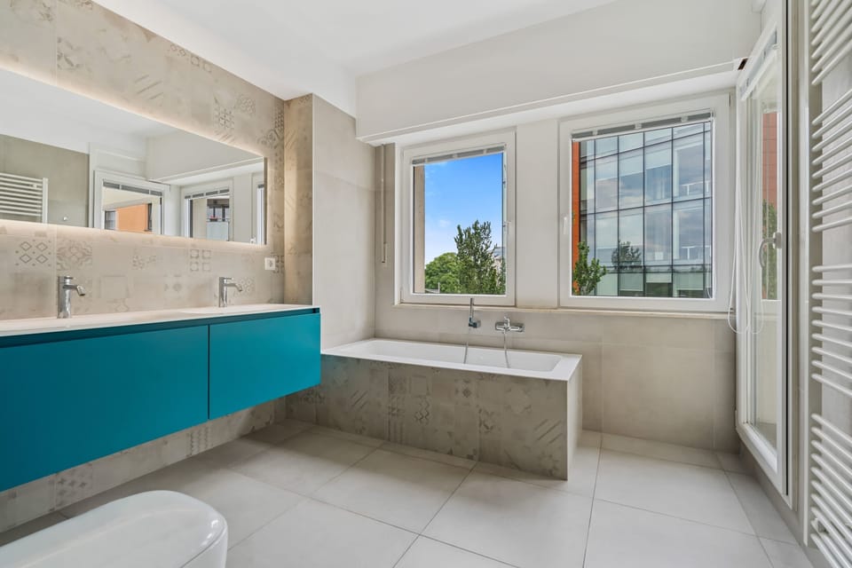 Freshen up with style in a bathroom that blends modern design with a view.