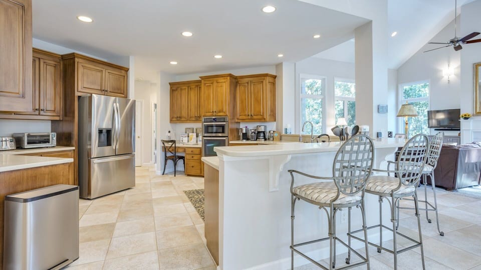 This spacious, well-appointed kitchen blends warm wood cabinetry with modern stainless-steel appliances for a polished, inviting feel.