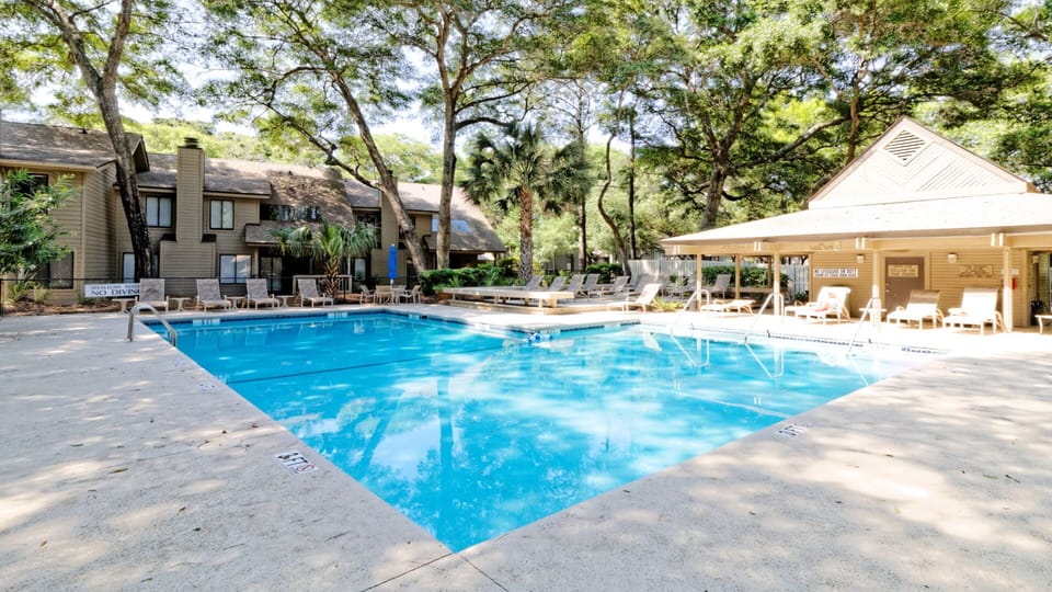 Community pool is tucked beneath a canopy of mature live oaks