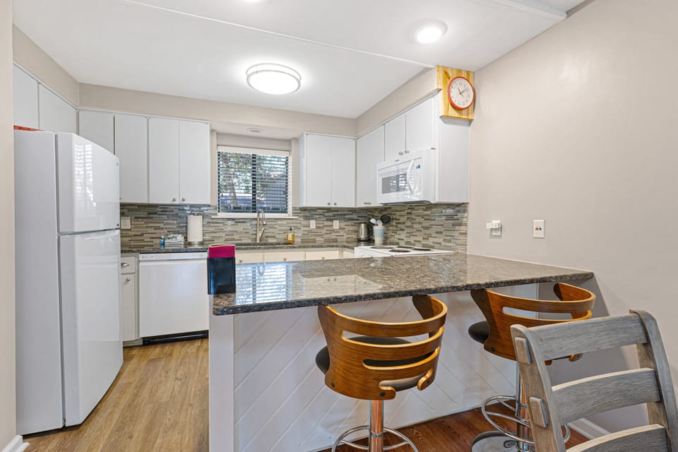 The kitchen features granite countertops, updated cabinetry, and a convenient breakfast bar with seating for casual meals.