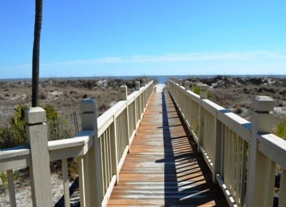 A scenic pathway offers a direct, peaceful walk to the beach, surrounded by lush  native Lowcountry greenery.