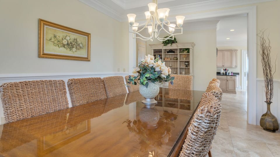 A generous dining table with woven chairs creates a warm, coastal-inspired setting perfect for gatherings.