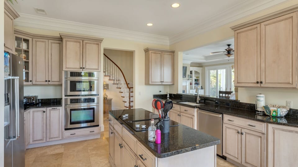 Stainless steel double ovens and a breakfast area framed by expansive windows make this kitchen perfect for both everyday living .
