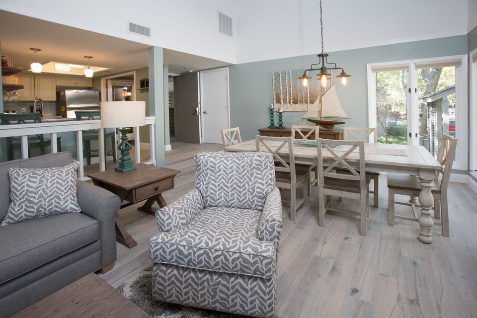 A comfortable sofa anchors the space, complemented by a cozy reading chair and warm wood accents.