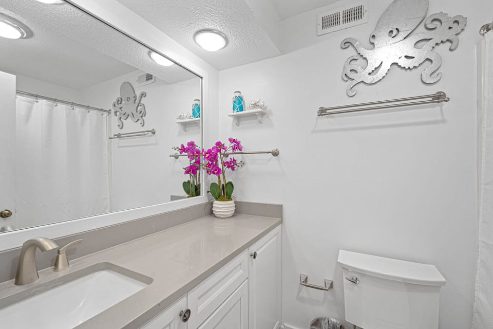 A spacious single vanity provides plenty of countertop room for personal items, while the tub and shower combination is perfect for a refreshing rinse after the beach or a relaxing soak.