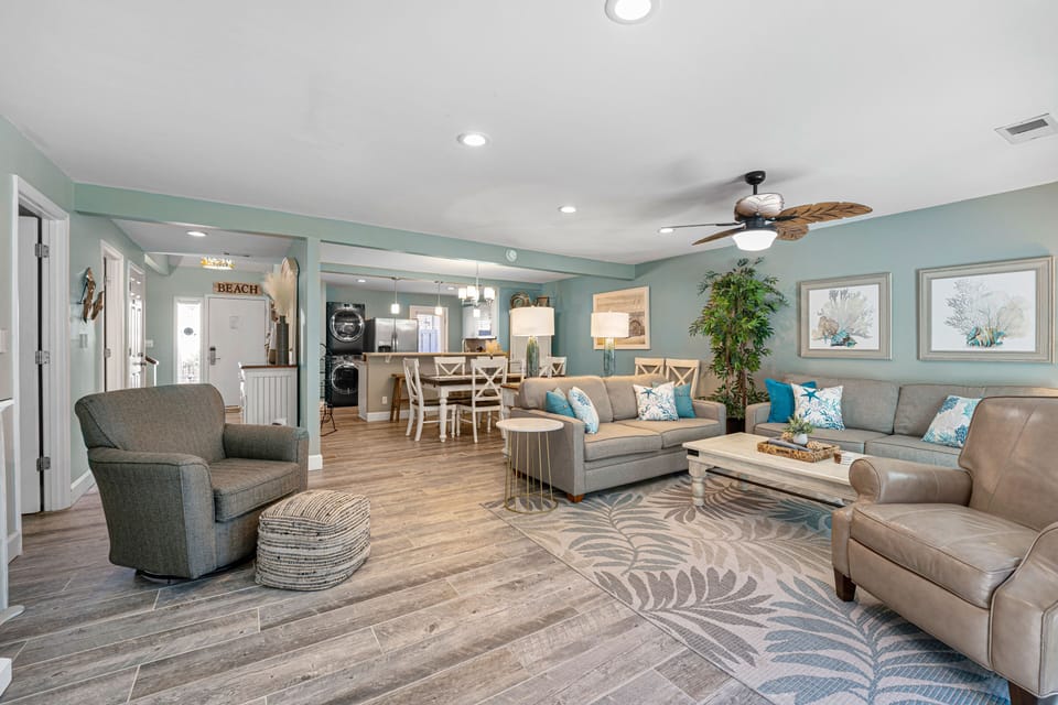 A bright open-concept living and dining area featuring coastal hues, stylish furnishings, and modern touches that create a warm